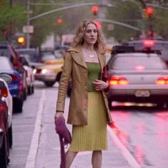 a woman is walking down the street with an umbrella in her hand and she's wearing a yellow dress