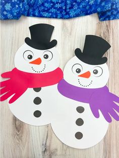 two paper snowmen with hats and scarfs