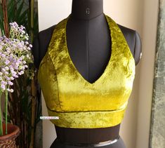 This Made to Order/Made to Measurement/Custom Made Indian Ethnic Blouse. - Fabric - Velvet - Color - Olive Green - Padded - Princess Cut - Deep V Neck - Halter Neck - Rich lining  - Sleeveless - Back Hook Closure - Extra margin and extra stitches included in the blouse PLEASE NOTE: BUYERS ARE RESPONSIBLE FOR ANY CUSTOMS AND IMPORT TAXES THAT MAY APPLY. This is a made to order product. If you opt for 'Made To Measurement Option', we will provide a measurement template and you can share the measurements likewise. If you want to opt for 'Standard Size', Please refer to the size chart provided in the listing. Shipping: Standard Shipping is done by DHL ecommerce and it mostly takes 2 to 3 weeks to deliver after dispatch. Express Shipping is done by DHL express and it mostly delivers within a we Halter V Neck Blouse, Halter Neck Blouse Designs Saree, Sleeveless Lengha Blouse, Halter Saree Blouse Design, Halter Neck Lehenga Blouse, Bohemian Fitted Sleeveless Blouse Piece, Fitted Bohemian Sleeveless Blouse Piece, Fitted Bohemian Blouse Piece With Padded Design, Fitted Bohemian Blouse Piece With Padding