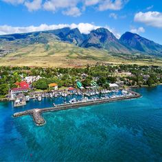 an aerial view of a marina with mountains in the background