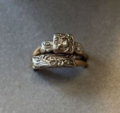 two gold and silver rings sitting on top of a table