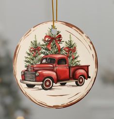 an old red truck with a christmas tree on it's back hanging from a string