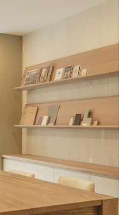 there are many books on the shelves above the table and in front of the window