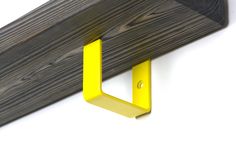 a wooden shelf with yellow brackets on it