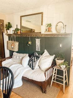 a bed with pillows and plants on top of it next to a fireplace mantel