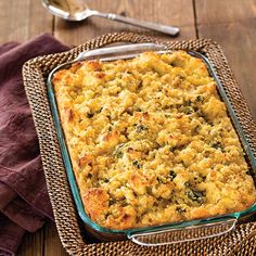 a casserole dish with bread and vegetables in it on a table next to a fork