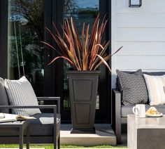 a large planter sitting on top of a patio next to a couch and table