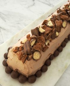 there is a chocolate dessert with nuts on the top and frosting in the middle