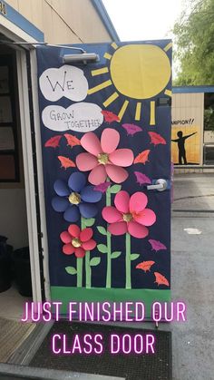 a door decorated with paper flowers and the words, just finished our class door art project