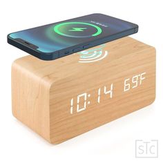 an alarm clock with a cell phone sitting on it's back end and the time displayed