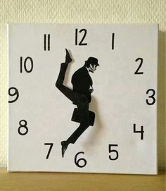 a black and white clock with a silhouette of a man dancing on it's face