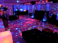 a party room with disco lights and black couches