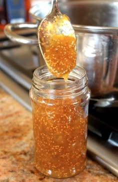 a spoon full of honey sitting on top of a jar