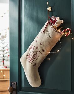 a christmas stocking hanging from the side of a door with a teddy bear on it