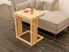 a small table sitting on top of a hard wood floor next to a chair and couch