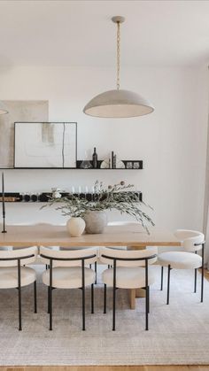 the dining room table is surrounded by white chairs