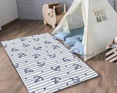 a child's room with a teepee tent, bedding and toys on the floor