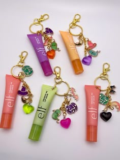 the keychains have various items on them, such as lip balm and lipstick