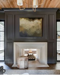 a living room filled with furniture and a fire place under a painting on the wall