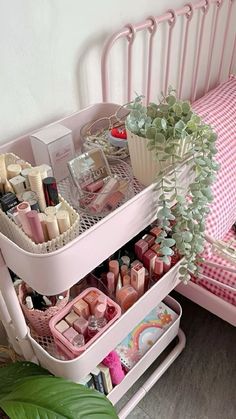 two trays with cosmetics and other items in them sitting on a pink chair next to a bed