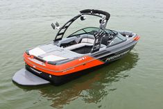 an orange and black boat is in the middle of the water with two seats on it