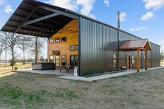 a large metal building sitting on top of a grass covered field