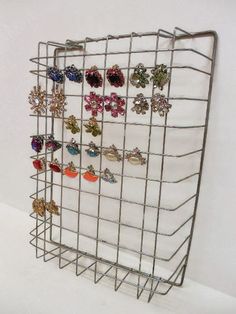 a metal rack with earrings hanging from it's sides and two rows of earring holders on each side