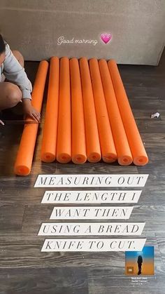 a woman kneeling down on the floor next to some orange plastic tubes with words written on them