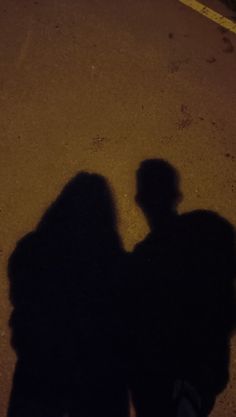 the shadow of two people standing next to each other