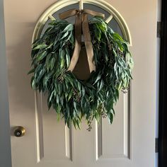 a wreath hanging on the front door of a house