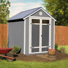 a garden shed with a wheelbarrow next to it