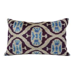 a purple and blue pillow with an ornate design on the front, sitting on a white background