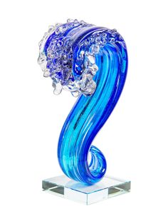 a blue glass sculpture sitting on top of a clear base with water swirling around it