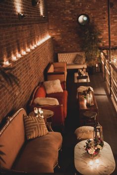 a room with couches, tables and candles on the wall next to each other