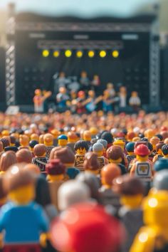 a large group of lego people standing in front of a stage at a music festival