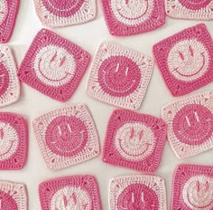 crocheted coasters with smiley faces on them are arranged in rows and laid out