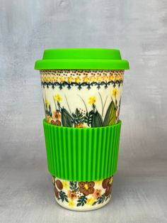 a green and white coffee cup sitting on top of a table