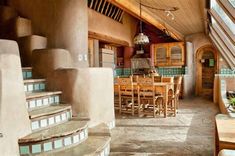 a dining room and kitchen area in an adobe - style home with stone steps leading up to the second floor