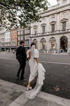 a bride and groom walking down the street