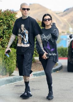 a man and woman are walking down the street holding hands with each other while wearing matching t - shirts