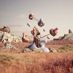 an abstract sculpture in the middle of a field with rocks and grass around it,