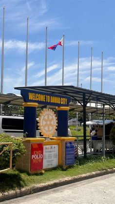 the welcome sign to lavao city is in front of some flags and other vehicles