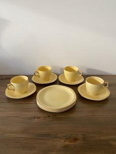 a table topped with yellow cups and saucers