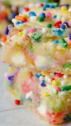 three colorful cookies stacked on top of each other with sprinkles all over them