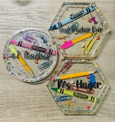 three clear hexagonal magnets with writing on them and school supplies in the middle