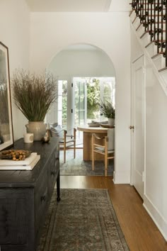 an entry way with stairs leading up to the dining room and living room in the background