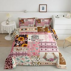 a bed covered in pink and brown patchwork with animals on the sheets, along with a white chair