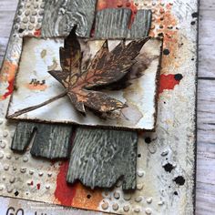 a leaf that is sitting on top of a piece of metal with rusted paint