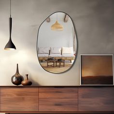 a living room with a large round mirror hanging on the wall above a wooden dresser