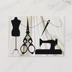 a business card with an image of sewing tools and a dressmaker's mannequin